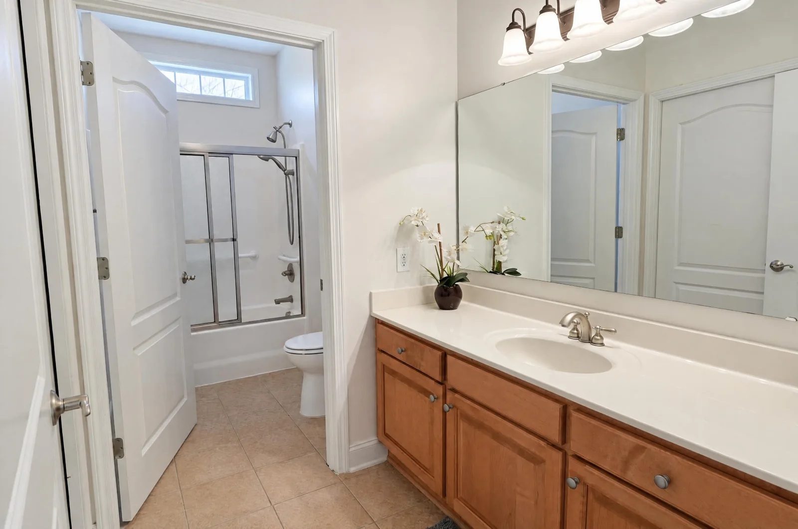 Hall bathroom with a long vanity and separate tub room